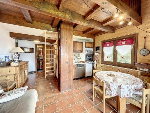 - une cuisine avec une table dans une chambre dotée de plafonds en bois dans l'établissement Charmant Duplex avec Mezzanine près du Téléski du Bouchet à Combloux - FR-1-560-11, à Combloux