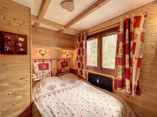 une chambre avec un lit dans une pièce en bois dans l'établissement Charmant Duplex avec Mezzanine près du Téléski du Bouchet à Combloux - FR-1-560-11, à Combloux