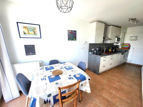 une cuisine avec une table et des chaises dans une pièce dans l'établissement Appartement Duplex 3P - Terrasse - Parking Privé - Les Sables-d'Olonne - FR-1-92-809, à Les Sables-dʼOlonne
