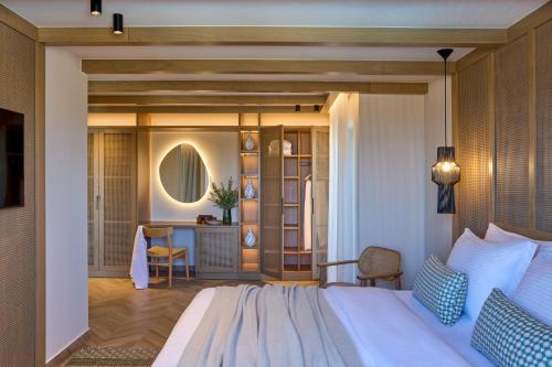 a bedroom with a bed and a desk at Mirabello Bay Luxury Resort in Agios Nikolaos