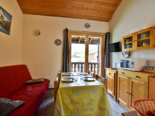 un salon avec une table et un canapé rouge dans l'établissement Charmant Duplex avec Balcon et Parking à Bernex, Proche Remontées Mécaniques - FR-1-498-36, à Bernex