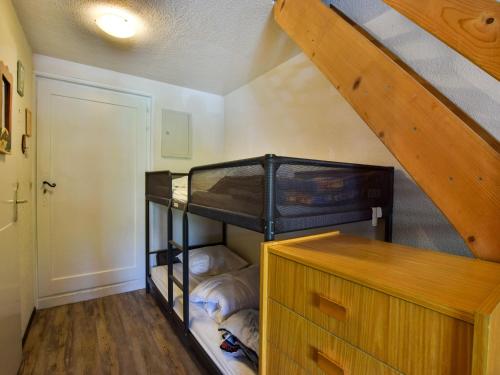 une chambre avec un lit superposé et un escalier dans l'établissement Charmant Duplex avec Balcon et Parking à Bernex, Proche Remontées Mécaniques - FR-1-498-36, à Bernex