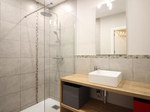 une salle de bain avec un lavabo et une douche dans l'établissement F2 bis au Mont-Dore, 200m du centre et Thermes, parking privé, animaux acceptés, 6 couchages - FR-1-415-69, à Le Mont-Dore