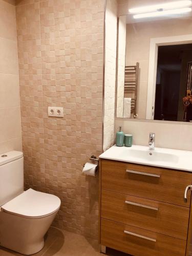 a bathroom with a toilet and a sink and a mirror at Alojamiento Mar y Bienestar in Laredo