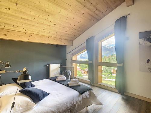 une chambre avec un grand lit et une grande fenêtre dans l'établissement Demi-chalet de luxe avec piscine et vue Mont Blanc - FR-1-560-71, à Combloux