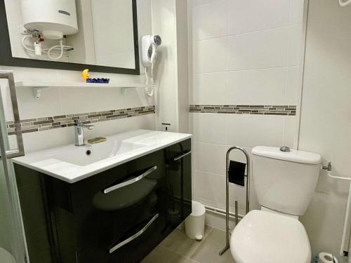 une salle de bain blanche avec un lavabo et des toilettes dans l'établissement Studio Cabine 4 pers, proche mer, clim, parking, animaux ok - FR-1-225-718, à Argelès-sur-Mer