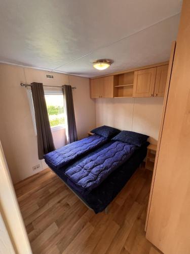 a small bedroom with a bed and a window at ZP 655 - Camping de Zandput in Vrouwenpolder