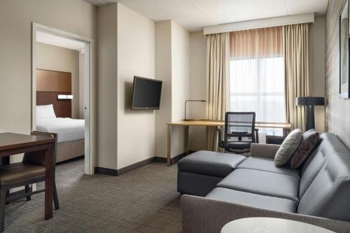 a hotel room with a couch and a bed at Residence Inn by Marriott Ottawa Airport in Ottawa