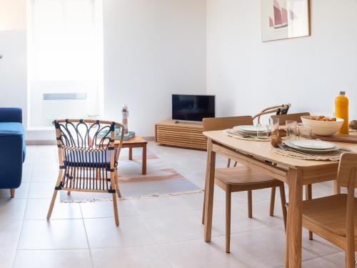 un salon avec une table et des chaises en bois dans l'établissement Duplex charmant T3/4 à 150m des criques, court commune, proche bourg à Port-Louis - FR-1-349-170, à Port-Louis