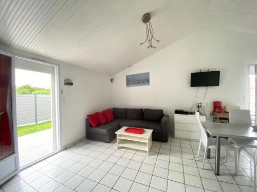un salon avec un canapé et une table dans l'établissement Maison de Charme au Calme avec Jardin Clos, WIFI, Proche Plage du Marais Girard, Animaux Acceptés - FR-1-231-133, à Bretignolles-sur-Mer
