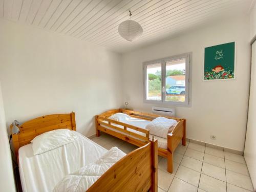 une chambre avec deux lits et une fenêtre dans l'établissement Maison charmante proche mer avec jardin, véranda et WIFI - Quartier La Sauzaie - FR-1-231-232, à Bretignolles-sur-Mer