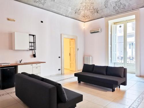 ein Wohnzimmer mit einem schwarzen Sofa und einer gelben Tür in der Unterkunft Al Donà in Bari