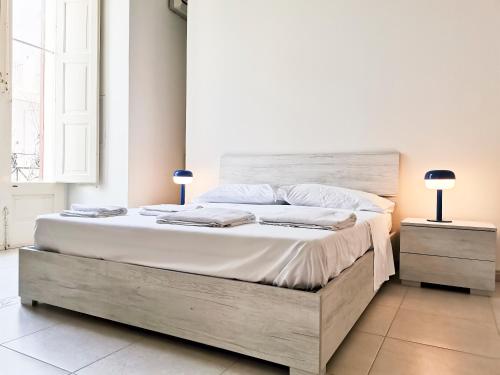 ein Schlafzimmer mit einem großen Bett mit einem hölzernen Kopfteil in der Unterkunft Al Donà in Bari