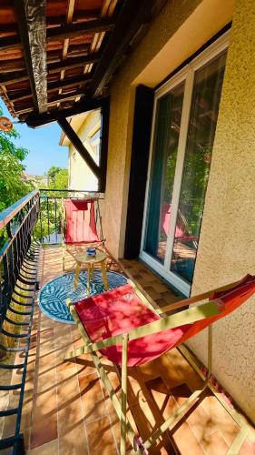 a balcony with a table and chairs on a house at Chez le Grand in Maraussan