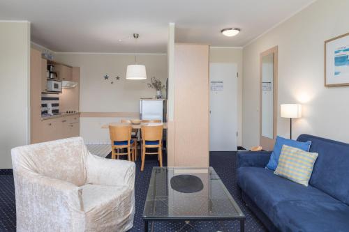 a living room with a couch and chairs and a table at Seestern - Charmante 2-Zimmer-Wohnung mit Balkon in Zingst