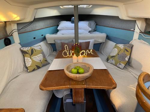 Una mesa en la parte trasera de un barco con un bol de fruta. en Cosy, Romantic, Fun Yacht Getaway, Torquay, England, en Torquay