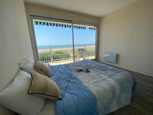 une chambre avec un lit avec vue sur la plage dans l'établissement Charmant T2 rénové avec balcon et parking, accès direct plage - Saint Brevin - FR-1-364-115, à Saint-Brévin-les-Pins