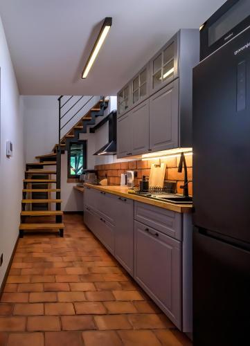 a kitchen with stainless steel appliances and a staircase at Zollhaus nad Zalewem Mietkowskim in Domanice