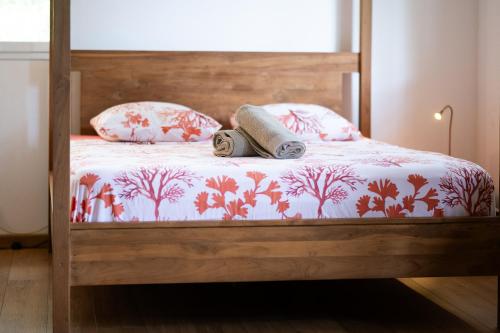 a bed with two pillows and a blanket with two towels at Lodge Nature in Saint-Leu