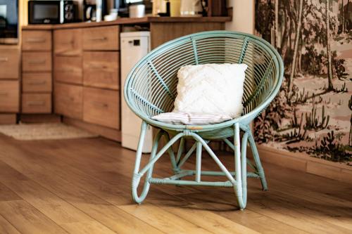 a green rattan chair with a pillow in a kitchen at Lodge Nature in Saint-Leu