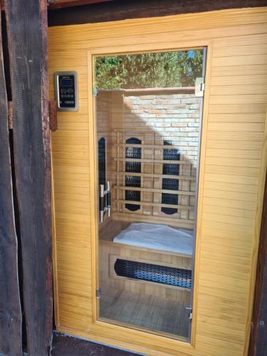 a glass door with a view of a sauna at Havko, Kendereš 309, Jatov 