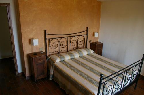 a bed in a room with two night stands and two lamps at Agriturismo Cervano in Toscolano Maderno