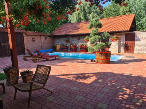 a patio with two chairs and a swimming pool at Havko, Kendereš 309, Jatov 