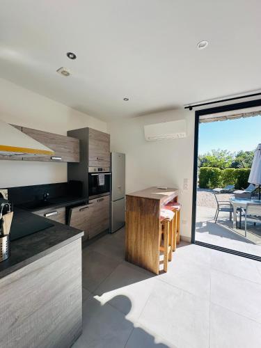 une cuisine avec une table et une grande porte coulissante en verre dans l'établissement N3 Maison T2 climatisé, à Ajaccio