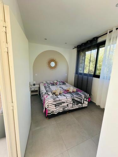 une chambre avec un lit et un miroir au mur dans l'établissement N3 Maison T2 climatisé, à Ajaccio