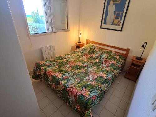 - une chambre avec un lit doté d'un couvre-lit coloré dans l'établissement T3 climatisé avec piscine, Wi-Fi et parking – À 200 m des plages et commerces - FR-1-316-291, à Six-Fours-les-Plages