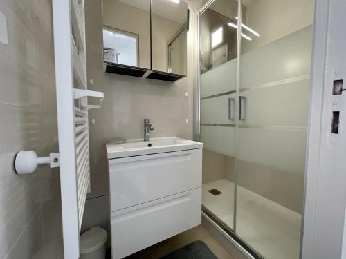 une salle de bain blanche avec un lavabo et une douche dans l'établissement Appartement T2 cabine avec climatisation, parking privatif à Sète - FR-1-338-466, à Sète