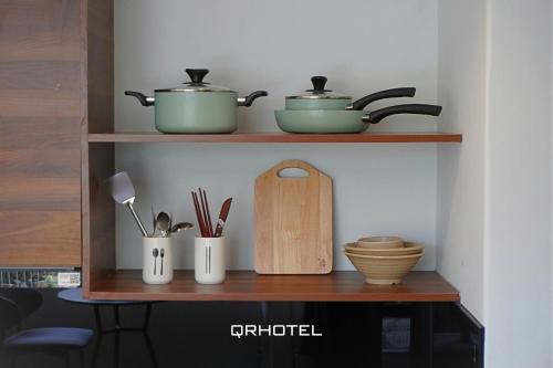 a shelf with pots and pans and utensils on it at QR Hotel Dalat in Xuan An