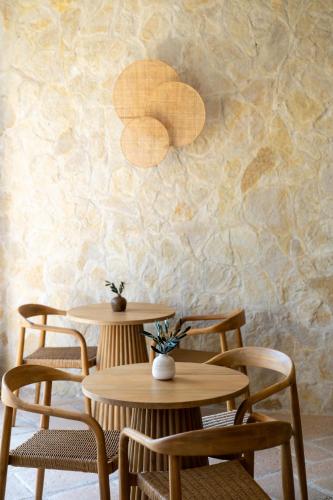 two tables and chairs in front of a stone wall at LES TERRASSES DE LORGUES - B&B de charme en Provence in Lorgues