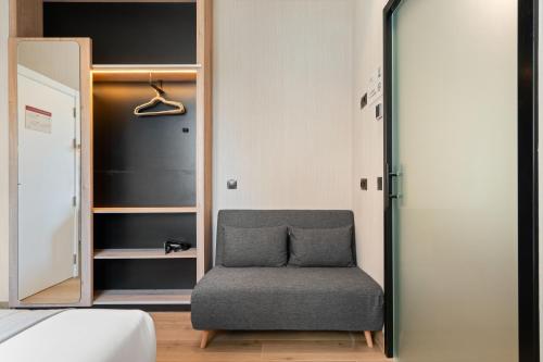 Una silla en una habitación con armario en Dobo Madrid Betanzos, en Madrid