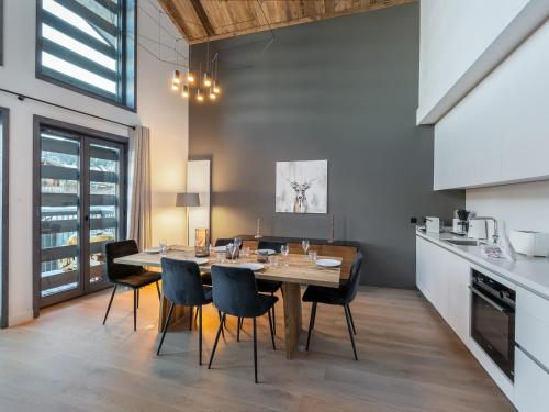 une cuisine et une salle à manger avec une table et des chaises dans l'établissement Appartement neuf proche pistes, 4 chambres avec sauna et cheminée - FR-1-562-63, à Courchevel