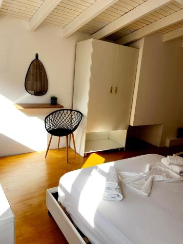 a bedroom with a bed and a chair and cabinets at "Villa Kanavos" apts in Matala