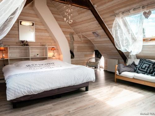 Un dormitorio con una cama grande en una habitación con paredes de madera. en Maison rénovée à Locmiquélic : 3 min du Batobus, proche sentiers et commerces, 4-6 pers. - FR-1-349-128, en Locmiquélic