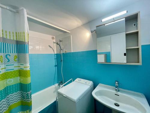 une salle de bain bleue avec un lavabo et des toilettes dans l'établissement Maison Confortable à 300m de la Plage des Dunes avec Jardin et Parking Privé - FR-1-231-188, à Bretignolles-sur-Mer
