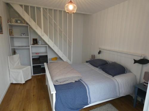 - une chambre avec un lit et un escalier dans l'établissement Maison familiale à Notre-Dame-de-Monts - Plage à 600m, jardin, 3 chambres, confort moderne - FR-1-540-153, à Notre-Dame-de-Monts