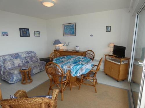un salon avec une table, des chaises et un canapé dans l'établissement Notre-Dame-de-Monts - T3 45m² - 4 pers - Balcon, Vue Mer - FR-1-540-203, à Notre-Dame-de-Monts