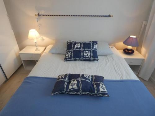 une chambre avec un lit avec deux oreillers dessus dans l'établissement Notre-Dame-de-Monts - T3 45m² - 4 pers - Balcon, Vue Mer - FR-1-540-203, à Notre-Dame-de-Monts