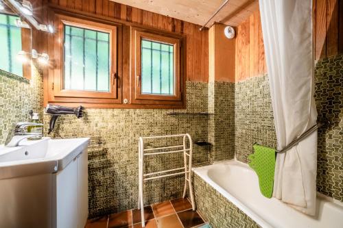 a bathroom with a bath tub and a sink at Chalet Chez Juju in Abondance
