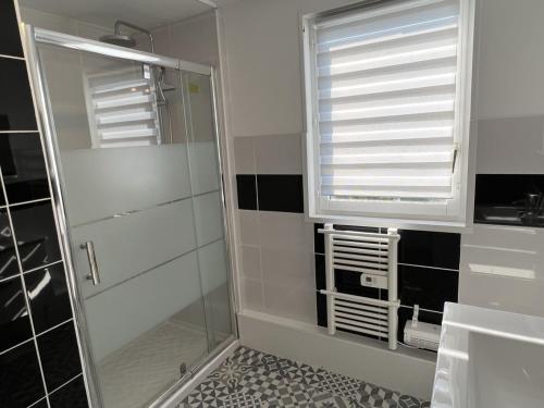 La salle de bains est pourvue d'une douche, d'une fenêtre et d'un miroir. dans l'établissement Charmant chalet 4P avec jardin privatif, proche plage et commerces à Merville-Franceville - FR-1-487-333, à Merville-Franceville-Plage