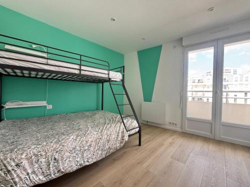 - une chambre avec des lits superposés et un mur vert dans l'établissement Appartement Moderne Centre-Ville, Proche Plage, 5 Couchages, Parking Privé - FR-1-197-555, à Les Sables-dʼOlonne