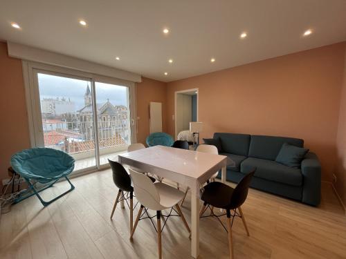 un salon avec une table, des chaises et un canapé dans l'établissement Appartement Moderne Centre-Ville, Proche Plage, 5 Couchages, Parking Privé - FR-1-197-555, à Les Sables-dʼOlonne