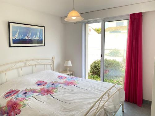 une chambre avec un lit blanc avec des fleurs dessus dans l'établissement Villa familiale avec piscine privée chauffée, 800m plage, WiFi - FR-1-231-260, à Bretignolles-sur-Mer