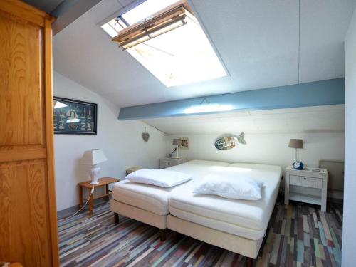 une chambre avec un lit blanc et une lucarne dans l'établissement Location Vacances La Palmyre - Maison 4/5 pers. avec Piscine, Proche Plages & Commerces. - FR-1-705-6, à La Palmyre