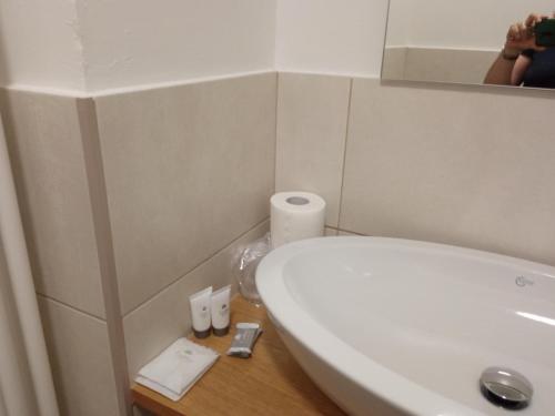 a bathroom with a white sink and a mirror at Casa sulla Piazzetta in Saluzzo