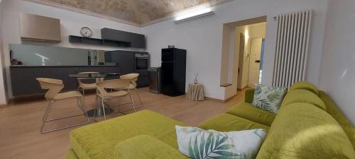 a living room with a green couch and a table at Casa sulla Piazzetta in Saluzzo