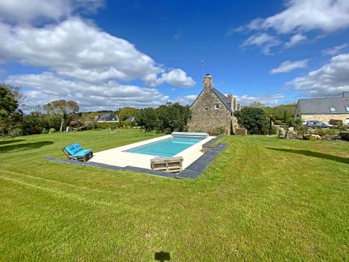 une grande cour avec une piscine en face d'une maison dans l'établissement Gîte indépendant de charme avec piscine chauffée à Kervignac - 6 couchages, proche plages - FR-1-349-188, à Kervignac
